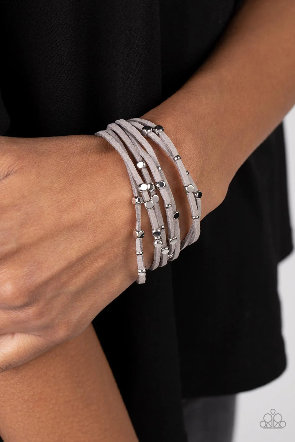 Paparazzi Accessories Clustered Constellations - Silver Row after row of gray suede cords layer around the wrist. Varying sizes of shiny silver studs coalesce across the cords in an out-of-this-world pattern for a starry statement. Features a magnetic clo