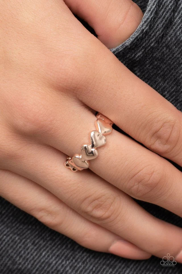 Paparazzi Accessories Rhythm of Love - Rose Gold Brushed in a high sheen shimmer, a dainty row of rose gold heart frames repeats across the finger for a romantic flair. Features a dainty stretchy band for a flexible fit. Jewelry