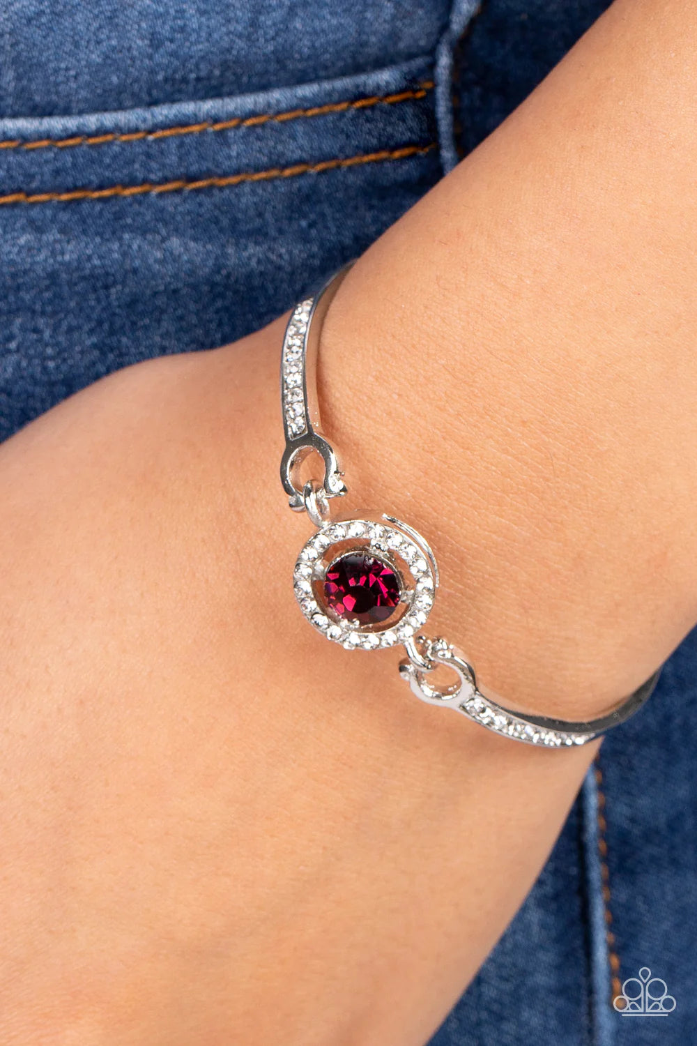 Paparazzi Accessories Focused and Fabulous - Purple A brilliant purple rhinestone sparkles inside a circular frame of dainty white rhinestones. Curved silver bars adorned with a row of rhinestones connect on each side of the frame, wrapping around the wri