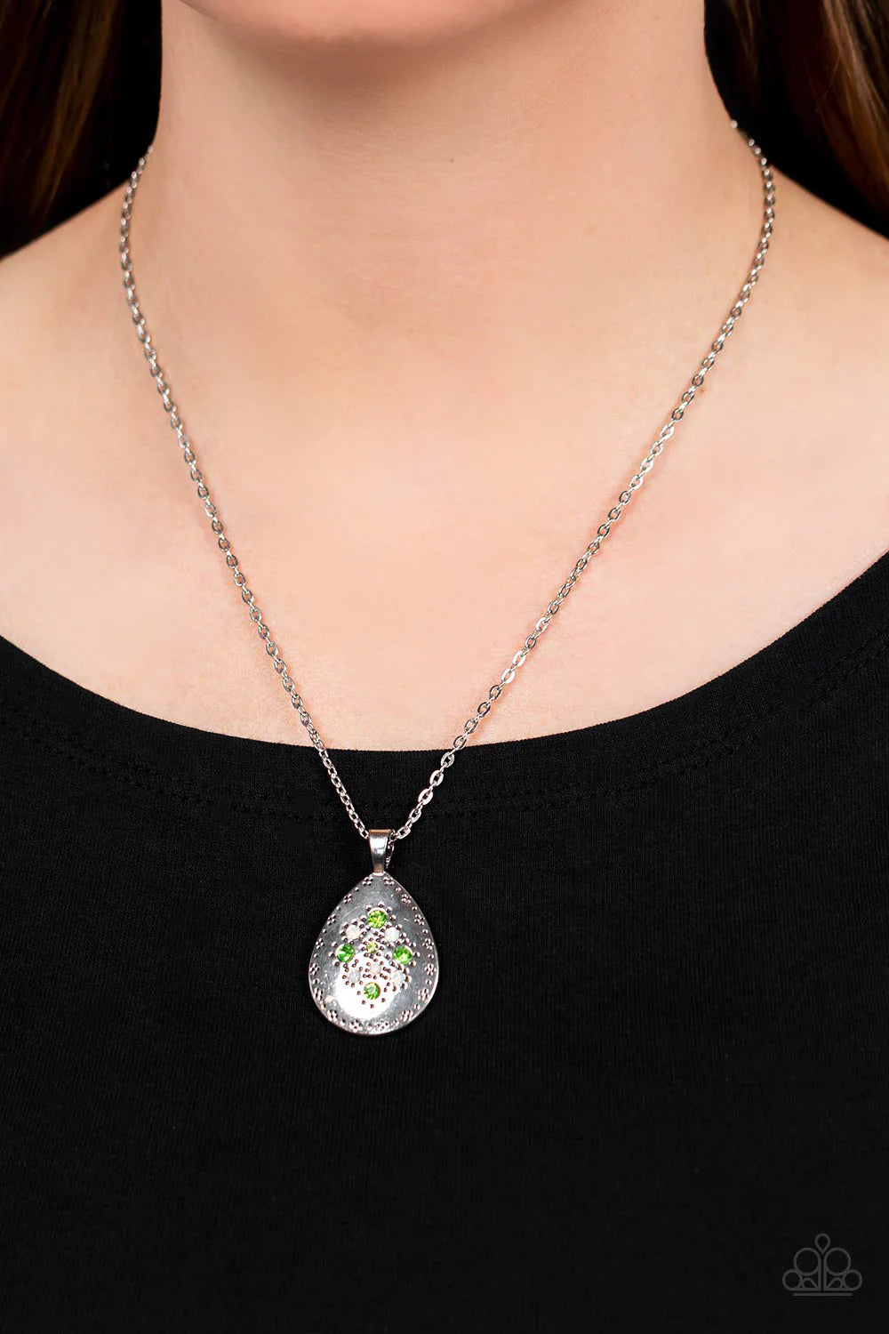 Paparazzi Accessories Cozy Cottage - Green Dainty green and opal rhinestones sparkle at the center of a silver teardrop pendant. Dotted in a subtle floral trim, the whimsical frame glides along a shiny silver chain below the collar for a seasonal look. Fe