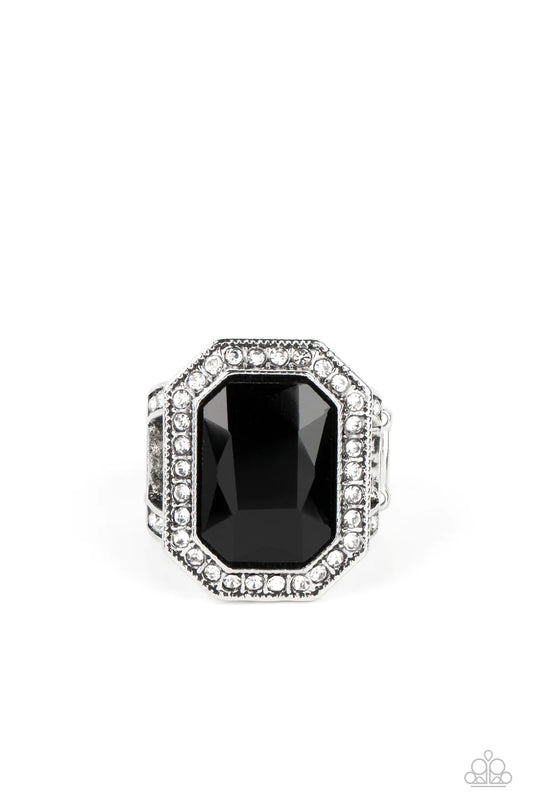 Paparazzi Accessories A Royal Welcome - Black An oversized, black, emerald-cut gem smolders inside a framework of studded silver texture and glitzy white rhinestones, resulting in an awe-inspiring statement piece that glamorously sits atop the finger. Fea