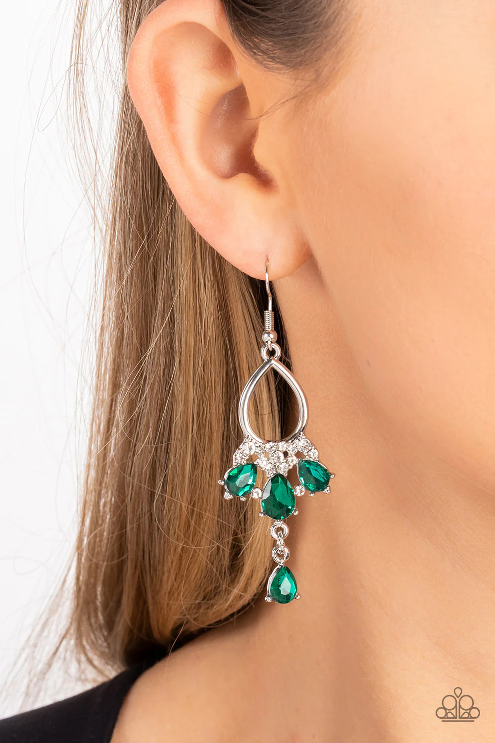 Paparazzi Accessories Coming in Clutch - Green A solitaire green teardrop rhinestone sways from the bottom of a fan of green rhinestone teardrops that flares out from a white rhinestone floral accent at the bottom of an airy silver frame, resulting in a m