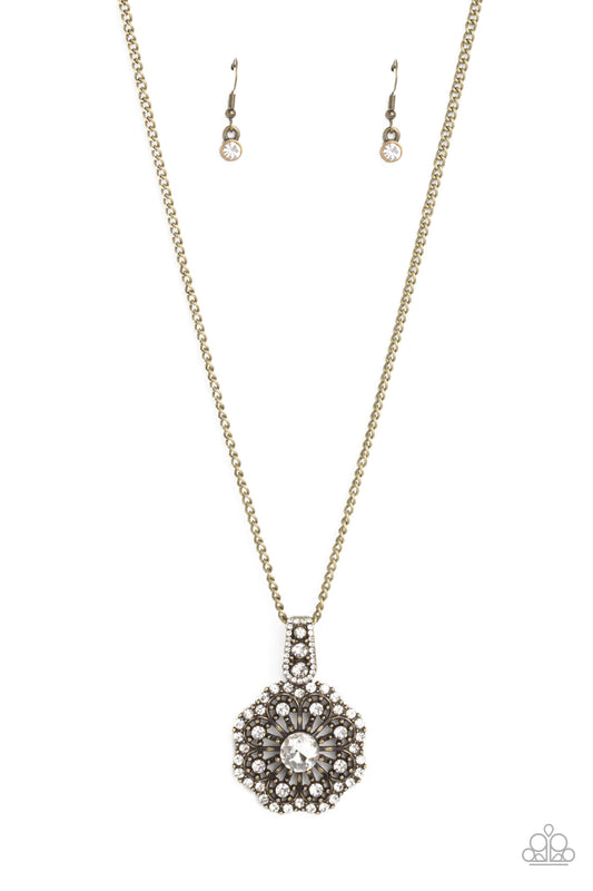 Paparazzi Accessories Bewitching Brilliance - Brass Sliding along a brass chain, a rhinestone-encrusted bail clasp displays a white, rhinestone-encrusted floral pendant. Blooming from a white gem center, airy brass petals dusted by a border of dainty rhin