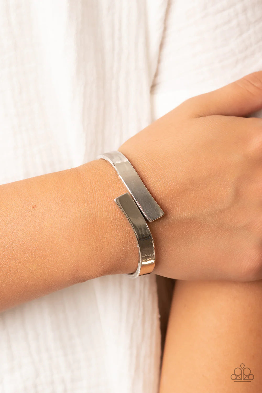Paparazzi Accessories Dare to Flare - Silver Two oversized silver ribbons delicately overlap across the center of the wrist, creating a stylish and stackable bangle-like cuff. Features a hinged closure. Sold as one individual bracelet.