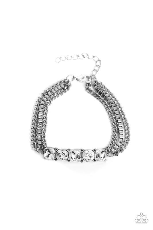 Paparazzi Accessories Tyrant Treasure - White A gritty mix of classic silver and silver box-chains stem from a row of faceted white gems, pressed into circular and square silver frames, creating edgy layers around the wrist. Features an adjustable clasp c