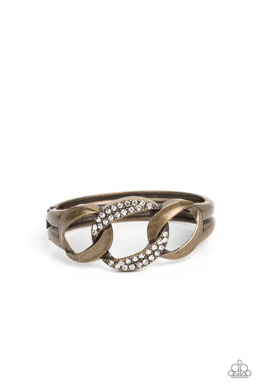 Paparazzi Accessories BOMBSHELL Squad - Brass A trio of rounded square brass links, featuring a hammered texture, interlock into an unapologetic display. The centermost link is dotted with glassy rhinestones, creating a sparkly fashion around the wrist. F