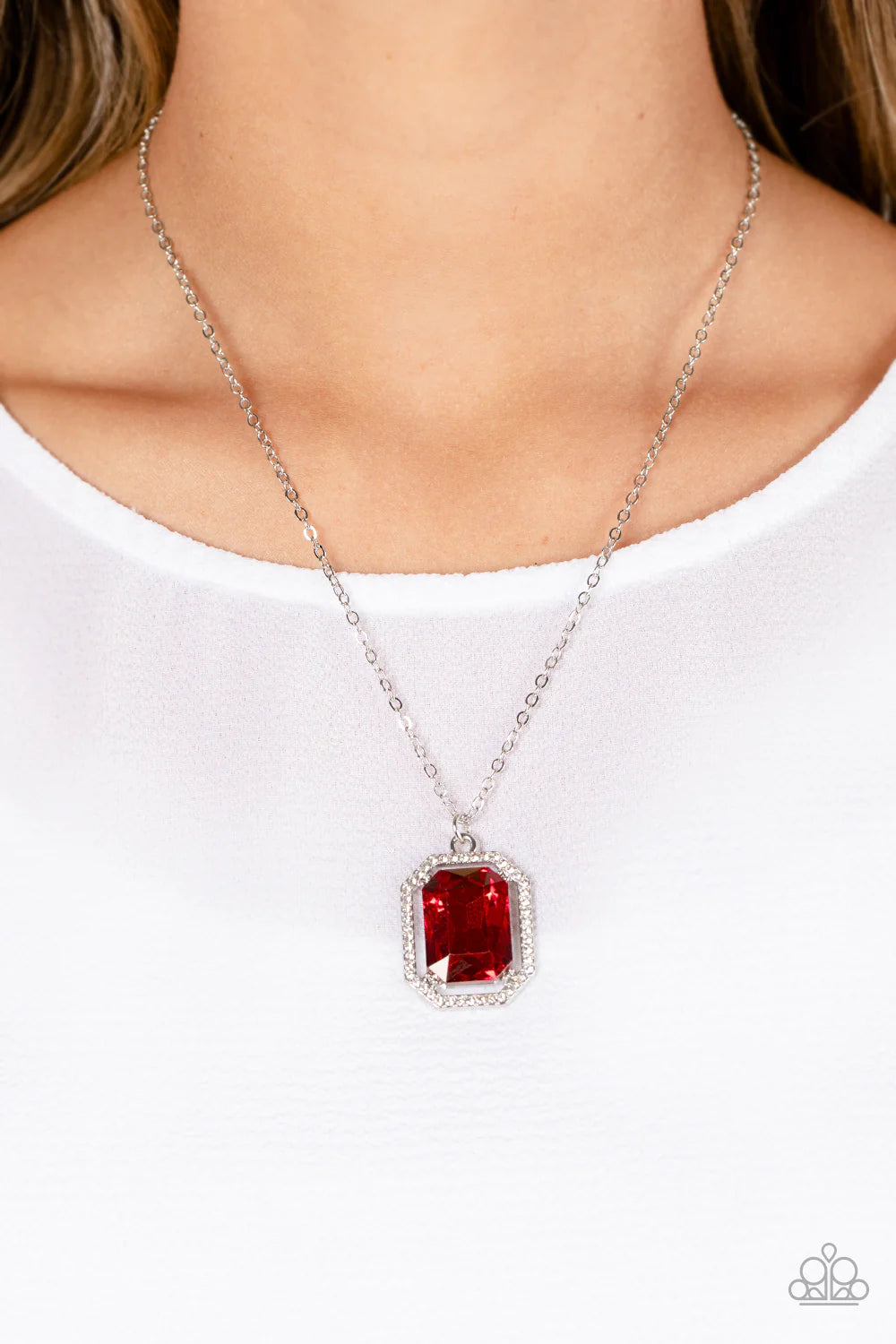 Paparazzi Accessories Galloping Gala - Red A dramatically oversized, emerald-cut red gem shimmers as it swings from the bottom of a long silver chain. Dainty white rhinestones create an airy frame that wrap around the reflective centerpiece, scattering li