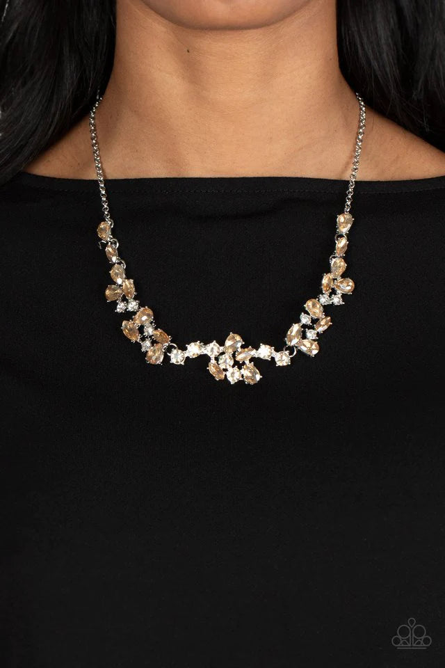 Paparazzi Accessories Welcome to the Ice Age - Brown Topaz gems and polished white rhinestones in a variety of inspired shapes gather together into scattered clusters that connect across the collar. The edgy teardrop, marquise, and round shapes attach to