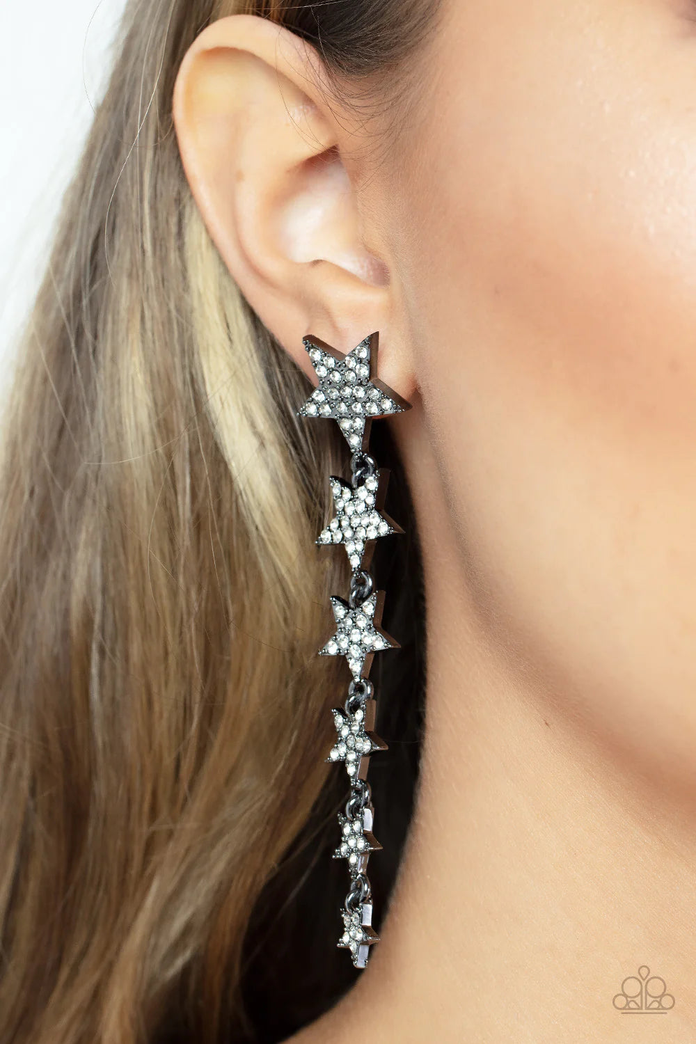 Paparazzi Accessories Americana Attitude - Black Dotted with dainty white rhinestones, a stellar collection of gunmetal stars decrease in size as they cascade from the ear for an out-of-this-world fashion. Earring attaches to a standard post fitting. Sold