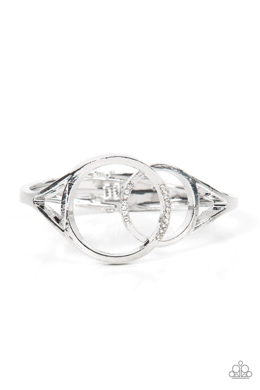 Paparazzi Accessories Scope of Experience - White Encrusted in sections of glassy white rhinestones, two oversized silver rings delicately overlap across the center of the wrist, resulting in a timeless bangle-like bracelet around the wrist. Features a hi