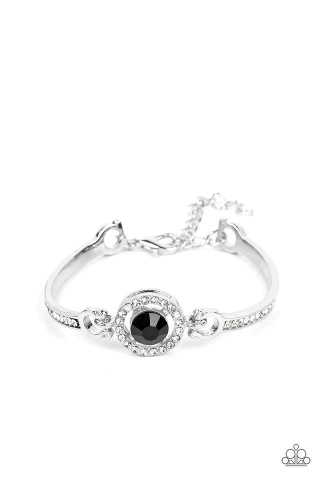 Paparazzi Accessories Focused and Fabulous - Black A brilliant black rhinestone sparkles inside a circular frame of dainty white rhinestones. Curved silver bars adorned with a row of rhinestones connect on each side of the frame, wrapping around the wrist
