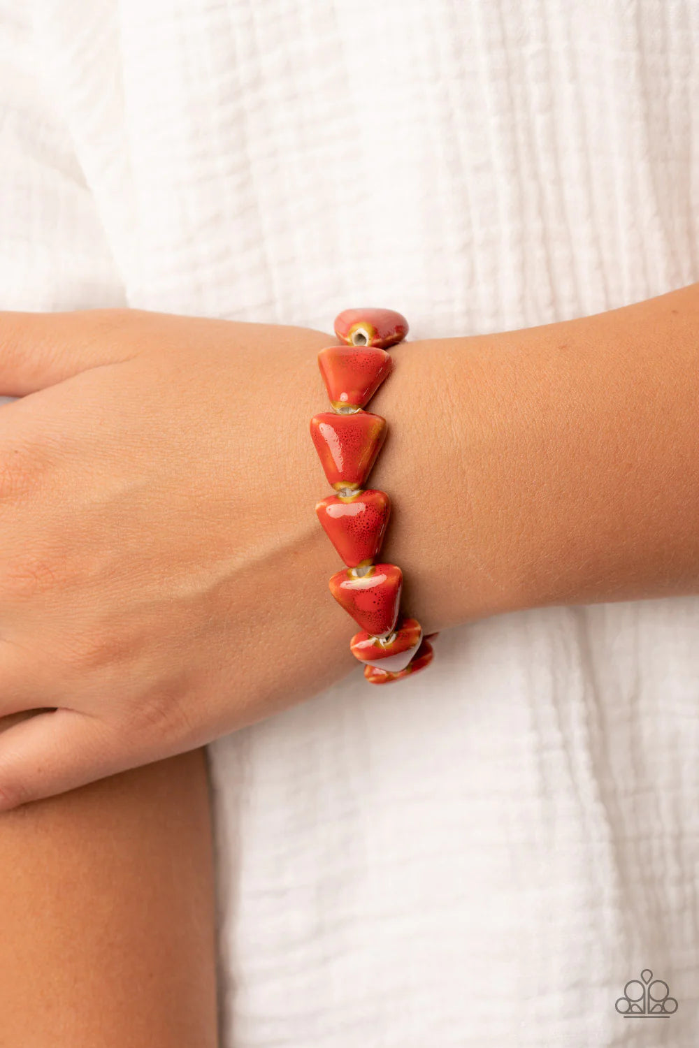 Paparazzi Accessories Shark Out of Water - Red Painted in a distressed red finish, ceramic beads shaped like shark teeth are threaded along a stretchy band around the wrist for a seasonal flair. Sold as one individual bracelet.