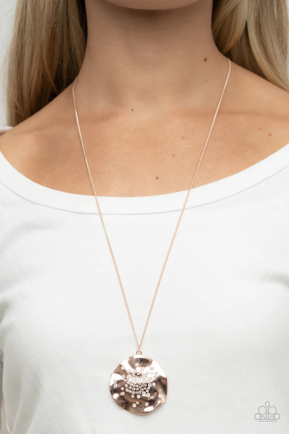 Paparazzi Accessories Boom and COMBUST - Rose Gold Dainty white rhinestones are haphazardly sprinkled across the front of an oversized and hammered rose gold disc, resulting in an explosion of shimmer at the bottom of an extended rose gold chain. Features