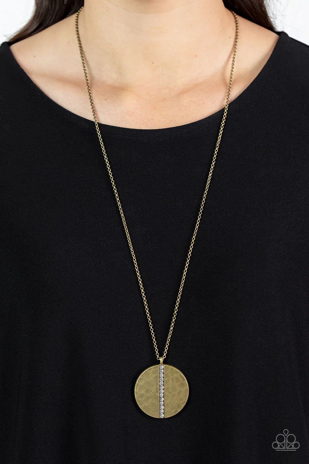 Paparazzi Accessories Token of My Gratitude - Brass An icy row of glittering white rhinestones is pressed into the center of a hammered brass disc, splitting the oversized pendant seemingly in two as it swings from the bottom of an extended brass chain fo