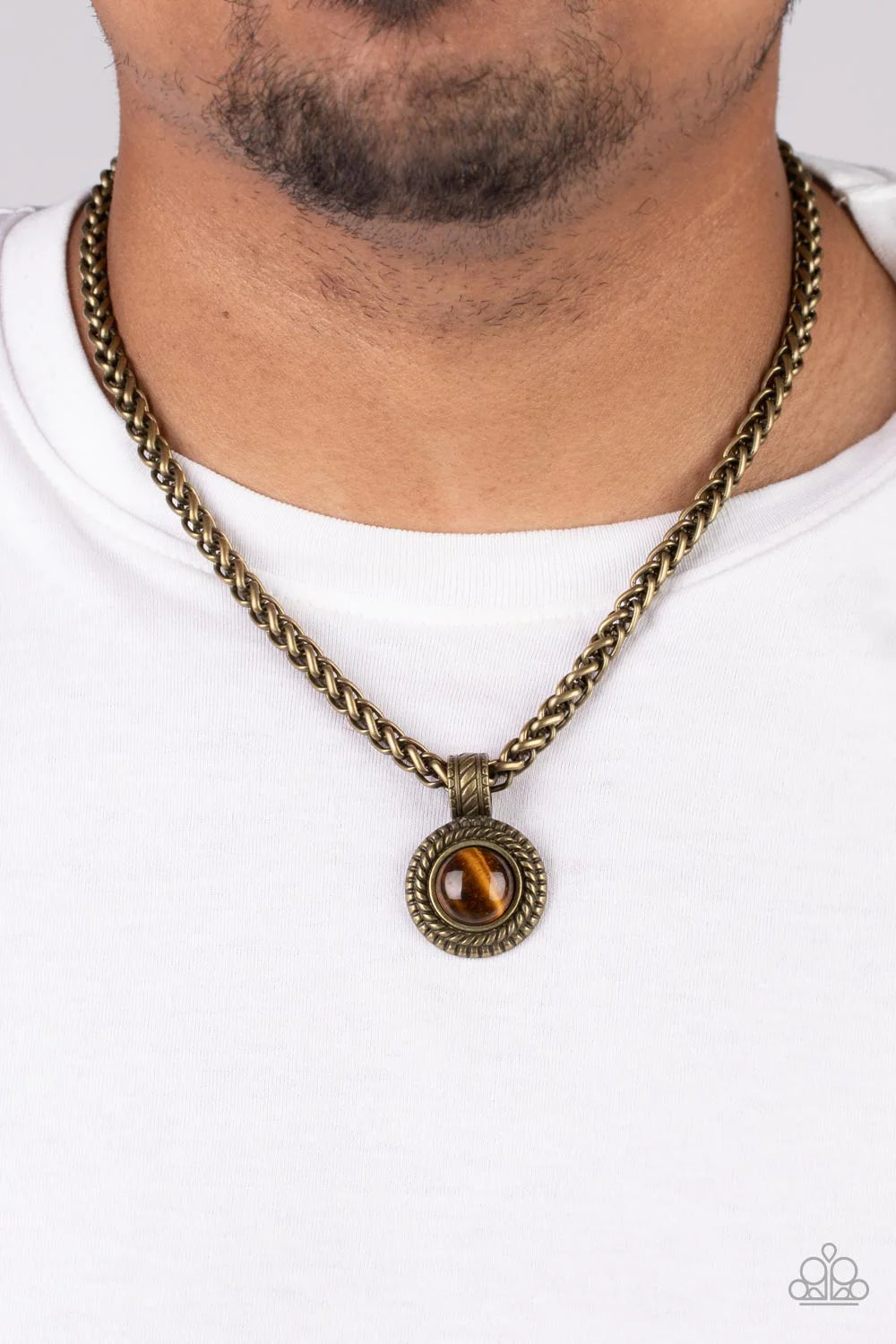 Paparazzi Accessories Pendant Dreams - Brass A textured brass frame spins around a tiger's eye stone center, creating a tranquil statement piece. The reflective pendant is anchored by a textured brass fixture, adding eye-catching dimension as the pendant