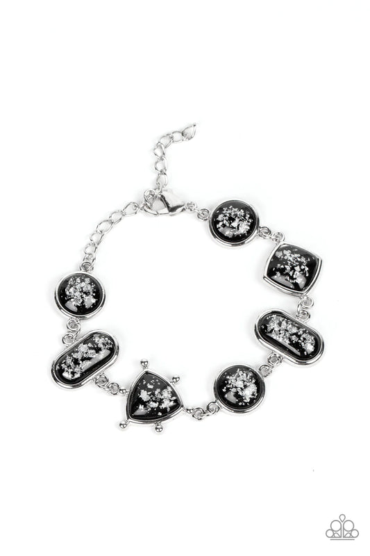 Paparazzi Accessories Speckled Shimmer - Black Glassy black beads speckled in flecks of silver shimmer delicately connect around the wrist in a glitzy geometric display. Features an adjustable clasp closure. Features an adjustable clasp closure. Sold as o