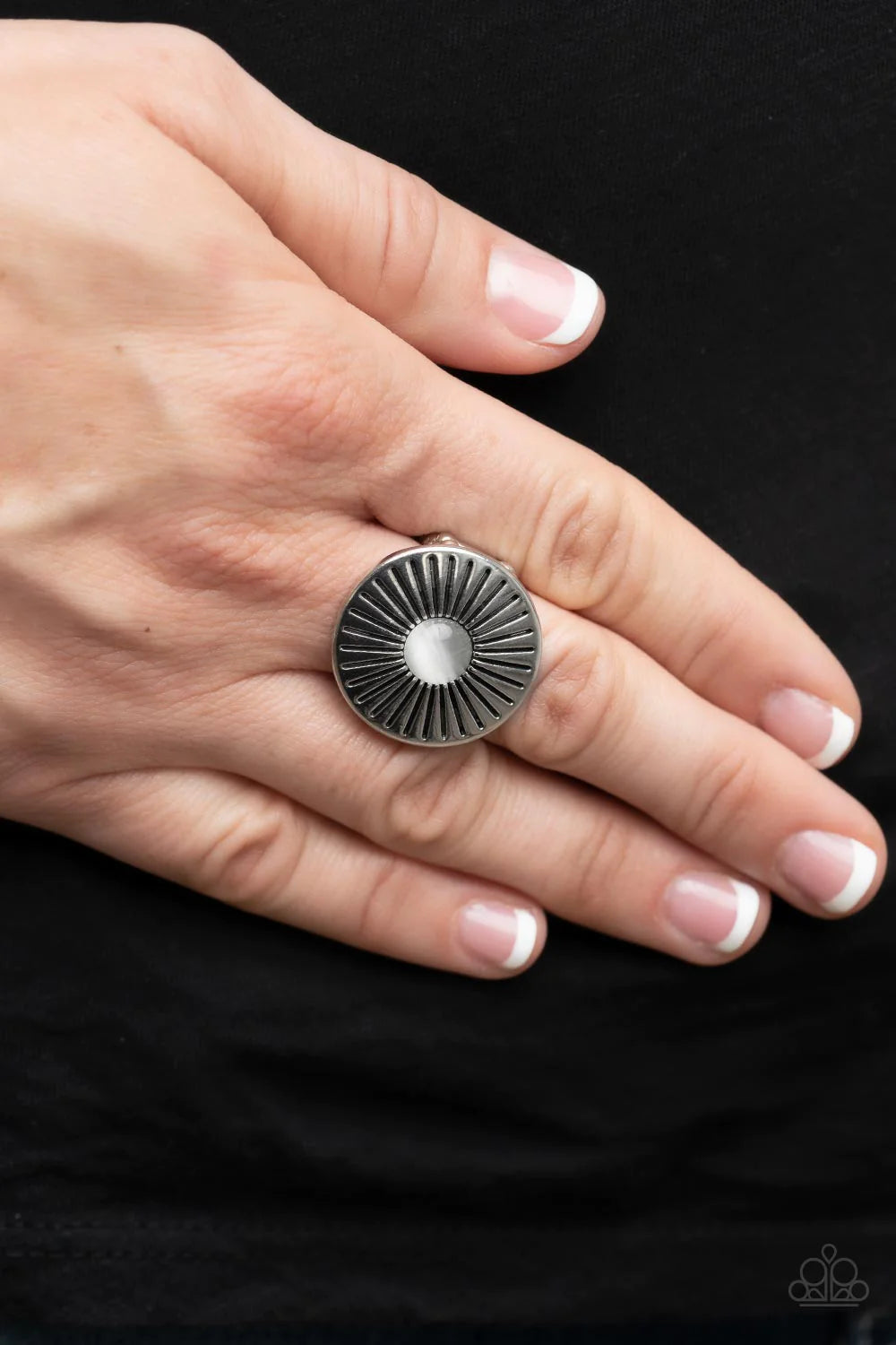 Paparazzi Accessories Everglade Eden - White Antiqued lines flare out from a white cat's eye stone center atop an oversized silver disc, creating an ethereal floral pattern atop the finger. Features a stretchy band for a flexible fit. Sold as one individu