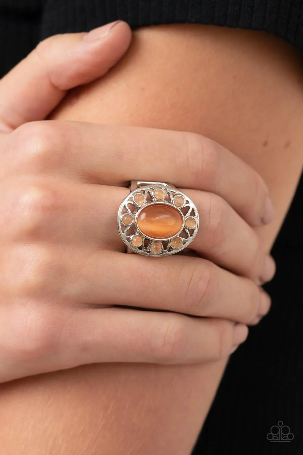 Paparazzi Accessories Sunny Solstice - Orange Dainty orange cat's eye stone beads radiate out from an oval orange cat's eye stone center, resulting in a radiant sunburst pattern atop the finger. Features a stretchy band for a flexible fit. Sold as one ind