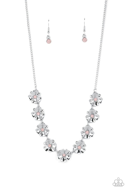 Paparazzi Accessories Petunia Palace - Pink Heart-shaped silver petals bloom from opaque Gossamer Pink rhinestone centers, creating colorful flowers. The dainty floral frames delicately dance below the collar, connecting into a whimsical centerpiece. Feat