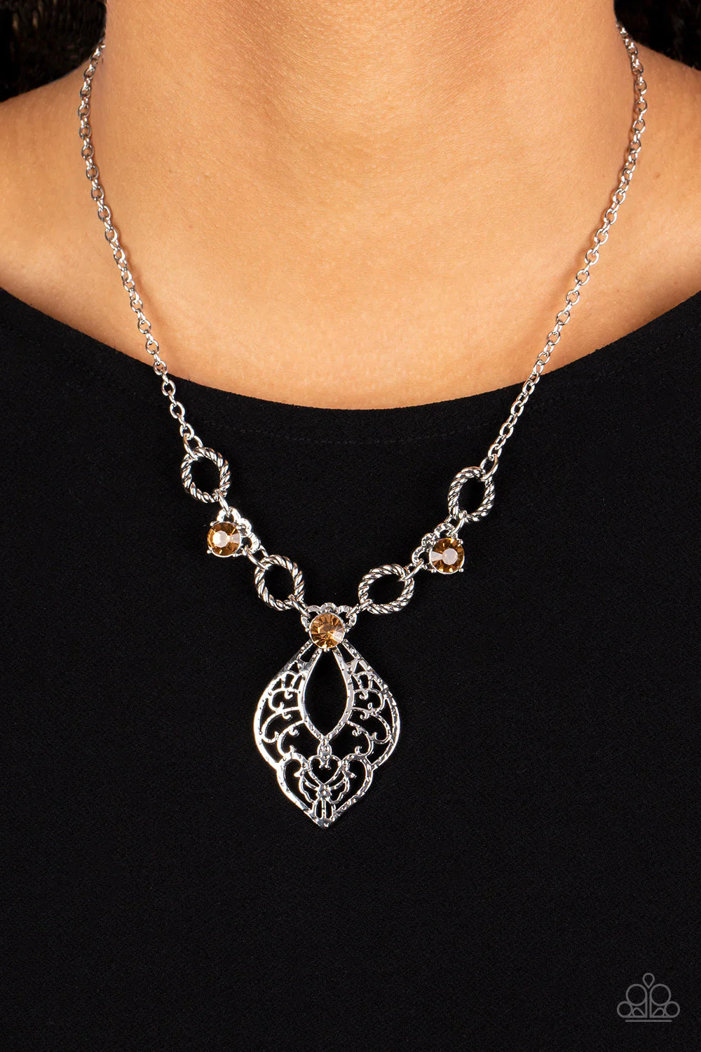 Paparazzi Accessories Contemporary Connections - Brown Twisted silver links and oversized golden topaz rhinestones delicately alternate below the collar. A hammered filigree filled silver pendant shimmers from the bottom of the centermost rhinestone, crea