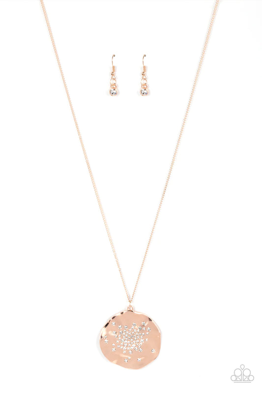 Paparazzi Accessories Boom and COMBUST - Rose Gold Dainty white rhinestones are haphazardly sprinkled across the front of an oversized and hammered rose gold disc, resulting in an explosion of shimmer at the bottom of an extended rose gold chain. Features