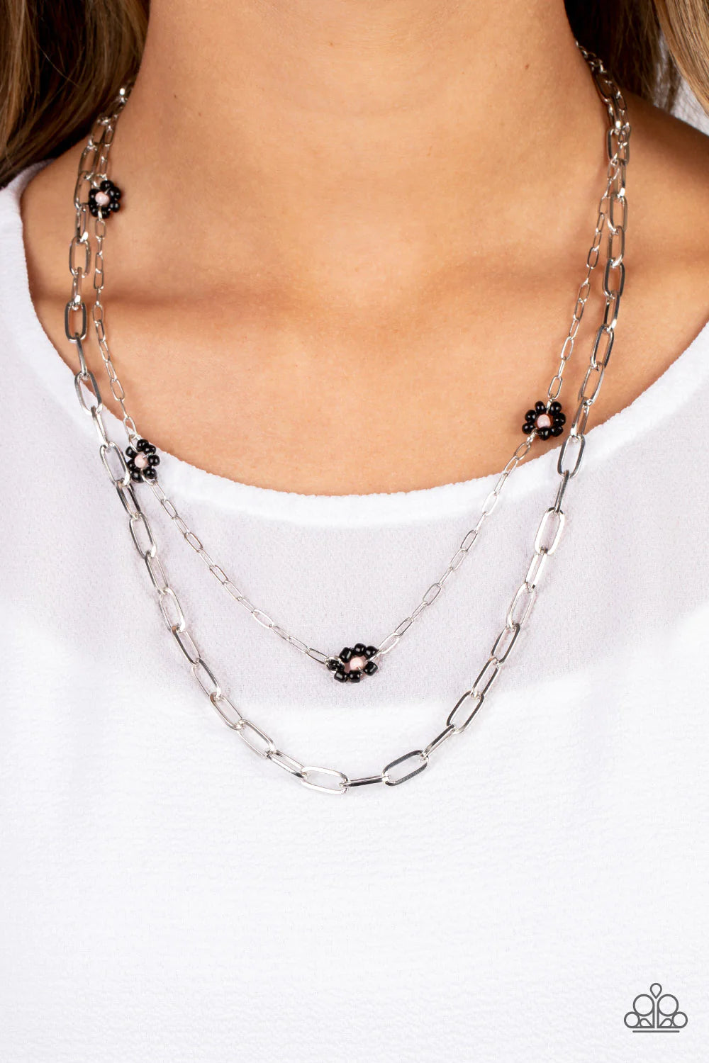 Paparazzi Accessories Bold Buds - Black Elongated silver ovals link together to create an industrially edgy sheen below the collar. A slightly daintier version of the same style of chain layers above, dotted with black seed bead flowers with pink centers