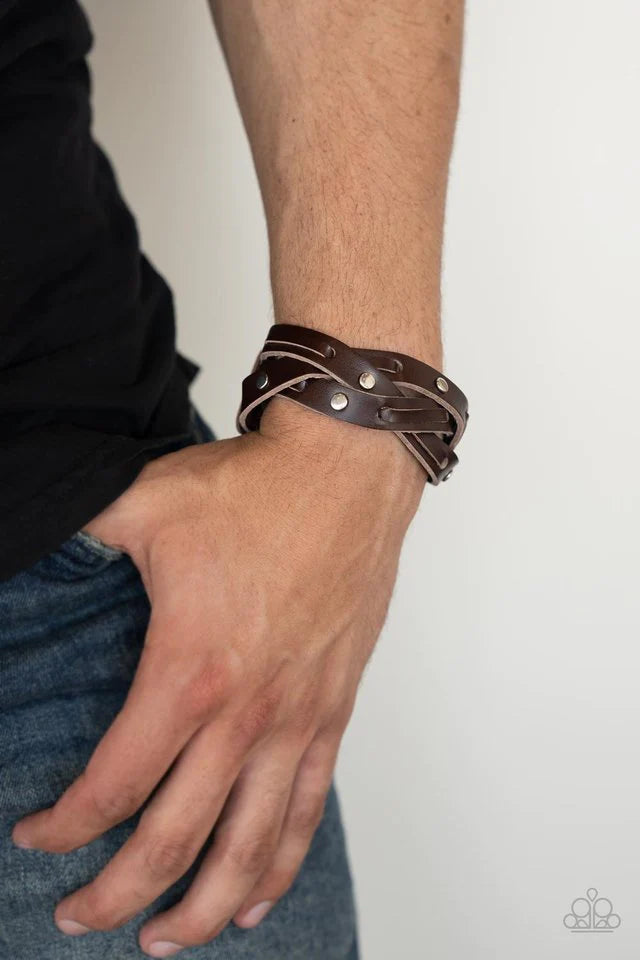 Paparazzi Accessories Rugged Roundup - Brown Featuring sections of silver studs and leather laces, brown leather bands weave into a rugged braid around the wrist. Features an adjustable snap closure. Jewelry