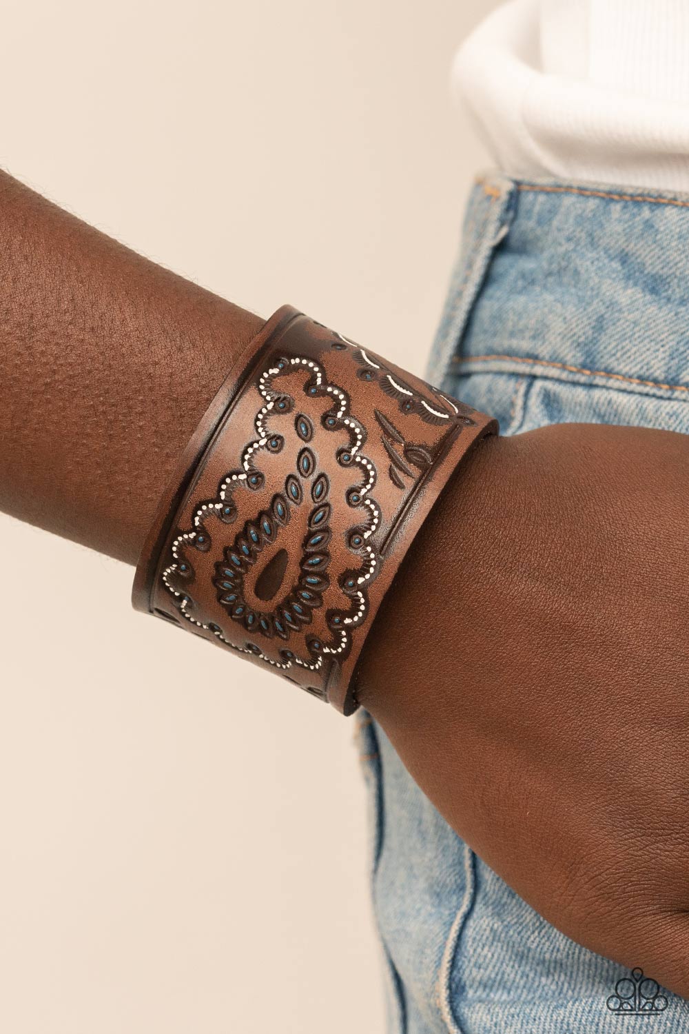 Paparazzi Accessories Paisley Pioneer - Blue Highlighted in white and blue paint, a rustic paisley pattern is stamped across the front of a distressed leather band for a rustic flair. Features an adjustable snap closure. Sold as one individual bracelet. J