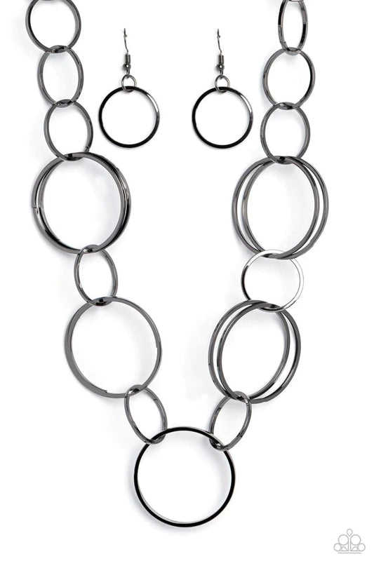Paparazzi Accessories Shimmering Symphony - Black A shimmering collection of thin gunmetal hoops in varying sizes interlock and coalesce down the neckline for a refined monochromatic statement piece. Features an adjustable clasp closure. Sold as one indiv