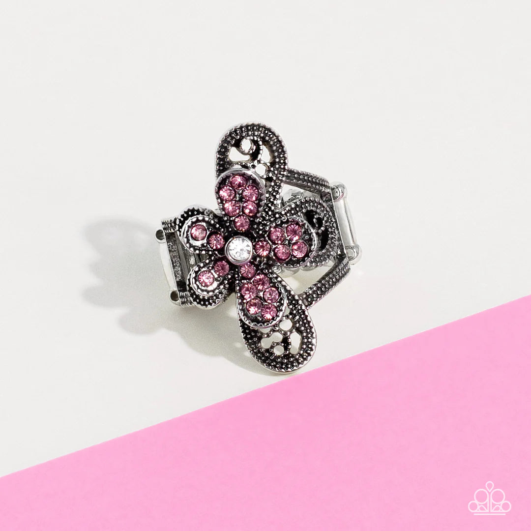 Paparazzi Accessories Gardens Escapade - Pink Dotted with a dainty white rhinestone center, silver petals overlaid with glittery pink rhinestones, sit atop studded silver filigree petals, creating a frilly floral centerpiece atop the finger. Features a st