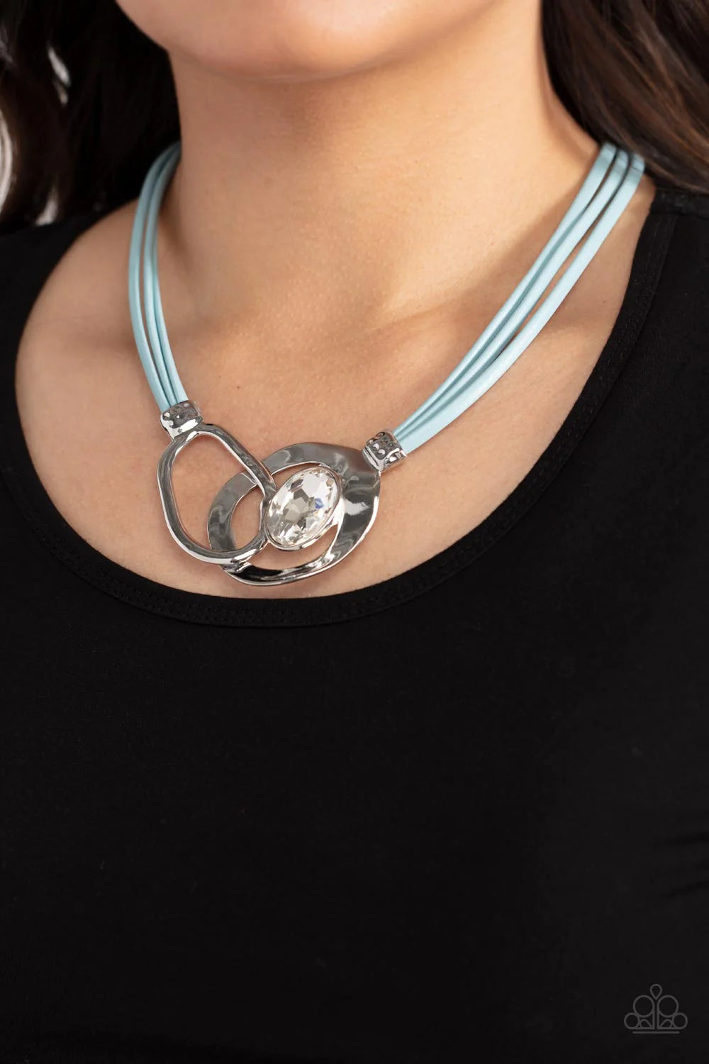 Paparazzi Accessories Californian Cowgirl - Blue Attached to shimmery strands of blue leather, a pair of oversized and warped silver links delicately overlaps into a contemporary centerpiece below the collar. An exaggerated white gem asymmetrically embell