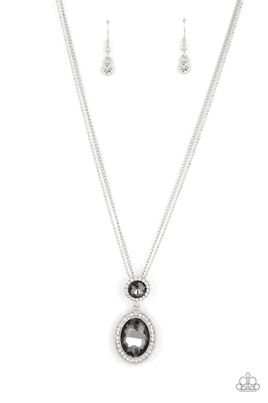 Paparazzi Accessories Castle Diamonds - Silver A large oval smokey rhinestone is encased in a border of rhinestone-dusted silver, as it's suspended from a smaller version of the same design. The stacked pendant then slides along a pair of silver chains in