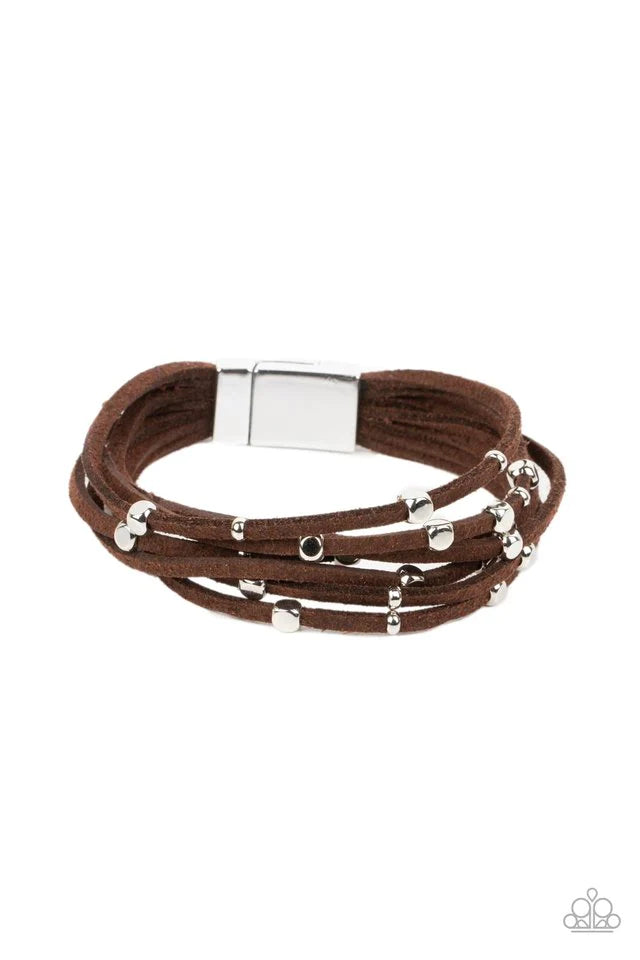 Paparazzi Accessories Clustered Constellations - Brown Row after row of brown suede cords layer around the wrist. Varying sizes of shiny silver studs coalesce across the cords in an out-of-this-world pattern for a starry statement. Features a magnetic clo