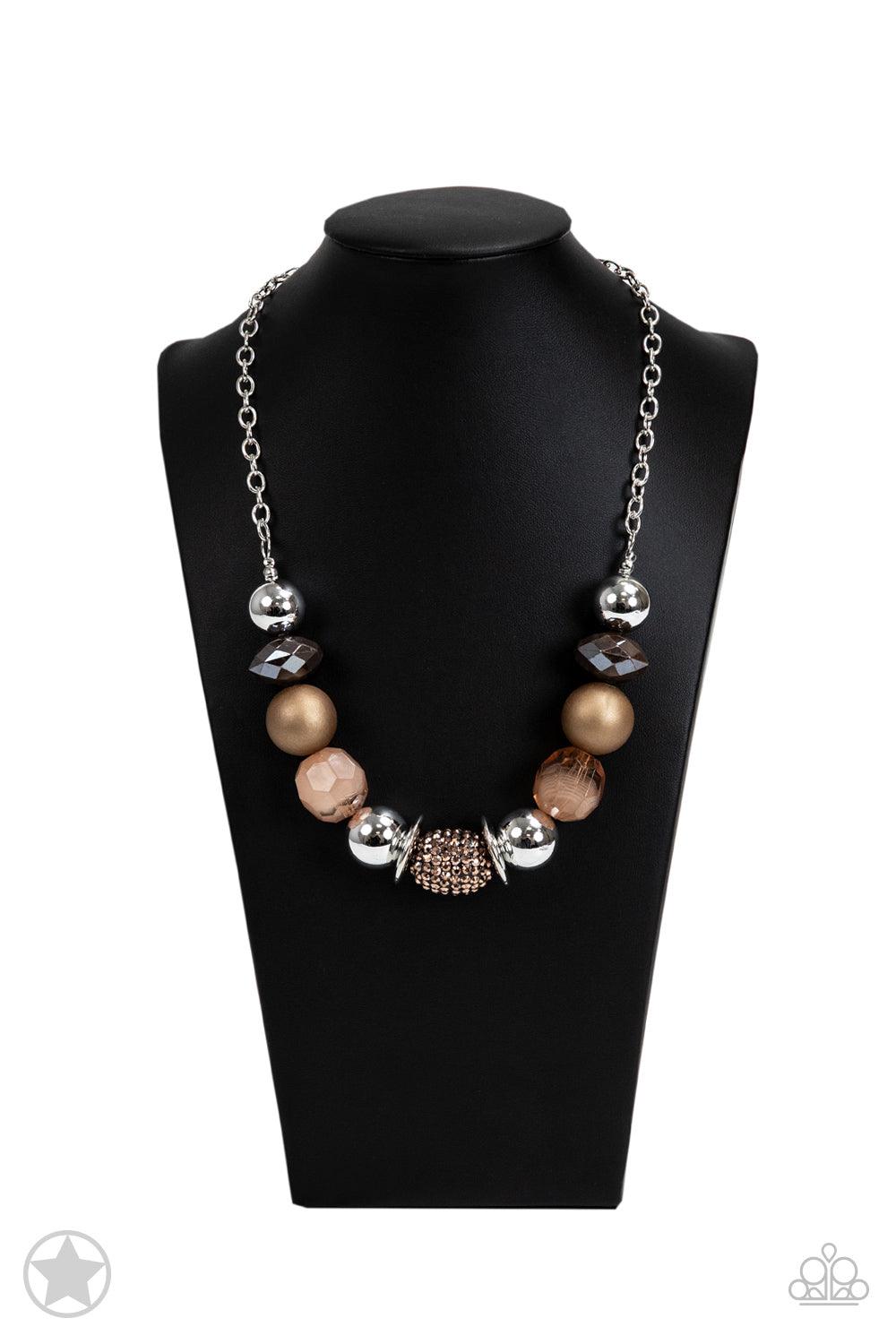 Paparazzi Accessories A Warm Welcome - Brown Warm beads in shades of brown and copper with reflective faceted edges and varying glazed finishes are offset by two shiny silver beads. An oblong bead studded with copper-toned rhinestones adds a dramatic acce