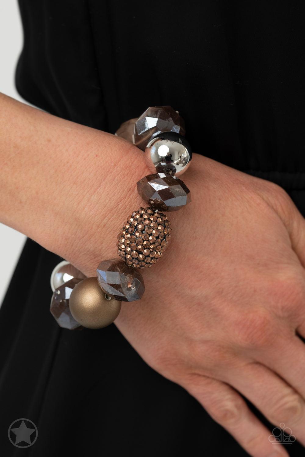 Paparazzi Accessories All Cozied Up Warm beads in shades of brown and copper with reflective faceted edges and varying glazed finishes are offset by two shiny silver beads. An oblong bead studded with copper-toned rhinestones adds a dramatic accent. Sold