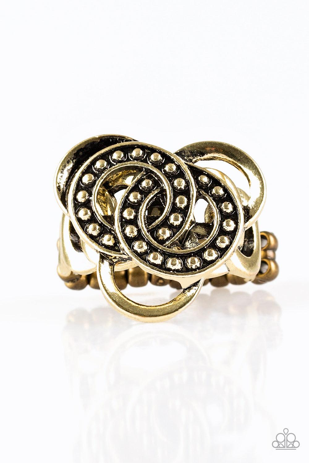 Paparazzi Accessories Dizzying Distraction - Brass Dotted in shimmery brass studs, antiqued rings sit atop a dizzying brass backdrop for an edgy geometric look. Features a dainty stretchy band for a flexible fit. Sold as one individual ring. Jewelry