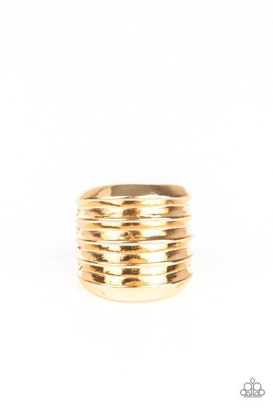 Paparazzi Accessories Hit Em Where It Hurts - Gold Rippling gold bands coalesce into a thick frame around the finger for a dramatic industrial look. Features a stretchy band for a flexible fit. Sold as one individual ring. Jewelry