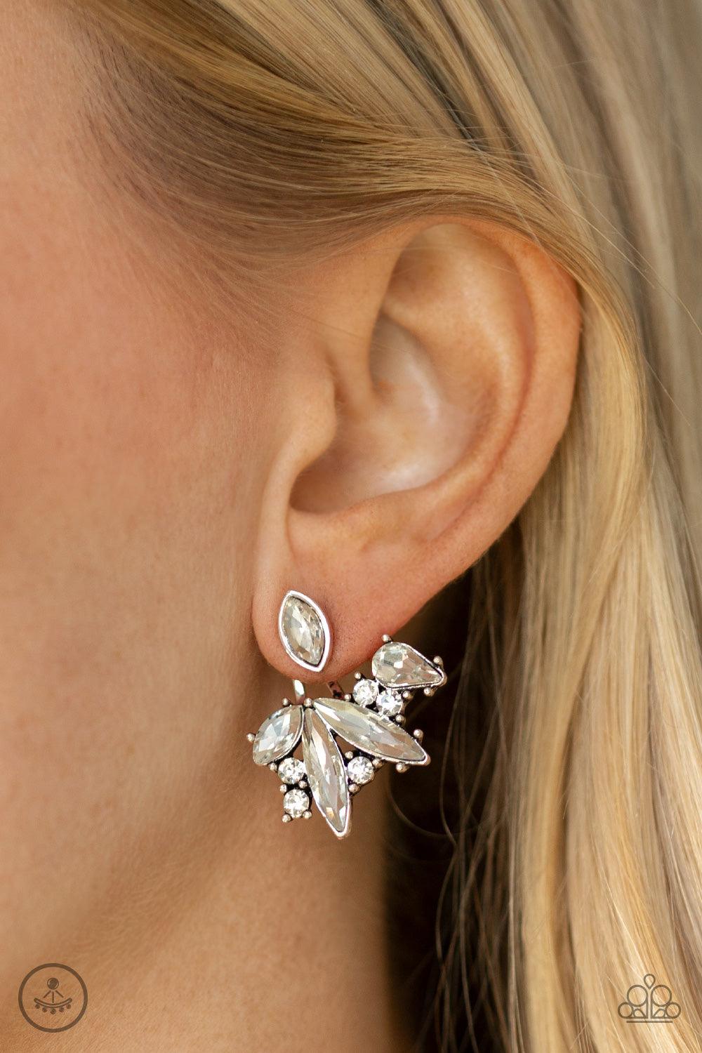 Paparazzi Accessories Deco Dynamite - White A solitaire white marquise cut rhinestone attaches to a double-sided post, designed to fasten behind the ear. Encrusted in a collision of mismatched white rhinestones, a double-sided post peeks out beneath the e