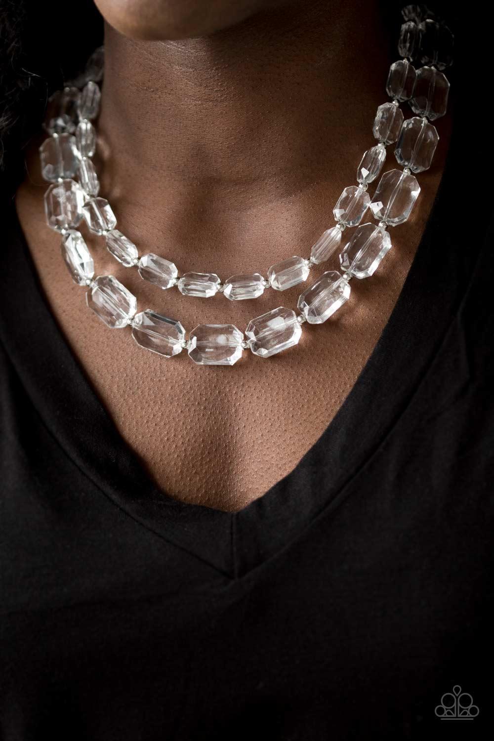 Paparazzi Accessories Ice Bank - White Infused with dainty silver beads, glassy white emerald-cut beads layer below the collar for an edgy look. Features an adjustable clasp closure. Sold as one individual necklace. Includes one pair of matching earrings.