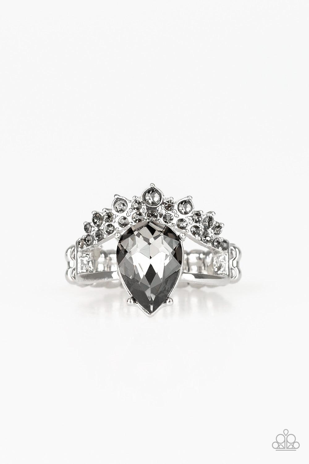 Paparazzi Accessories If The Crown Fits - Silver A shiny silver bar and smoky rhinestone encrusted bar arc across the finger, coalescing into an airy band. Featuring a regal teardrop cut, a glittery smoky rhinestone is pressed into the bands for a stateme