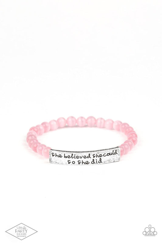 Paparazzi Accessories So She Did - Pink A collection of dainty pink cat’s eye stone beads and an antiqued frame stamped in the inspirational phrase, “She believed she could, so she did,” are threaded along a stretchy band around the wrist for a whimsical