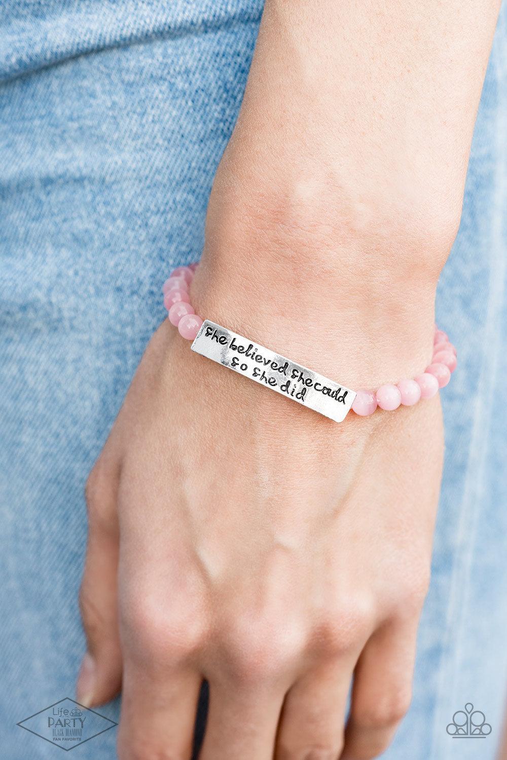 Paparazzi Accessories So She Did - Pink A collection of dainty pink cat’s eye stone beads and an antiqued frame stamped in the inspirational phrase, “She believed she could, so she did,” are threaded along a stretchy band around the wrist for a whimsical