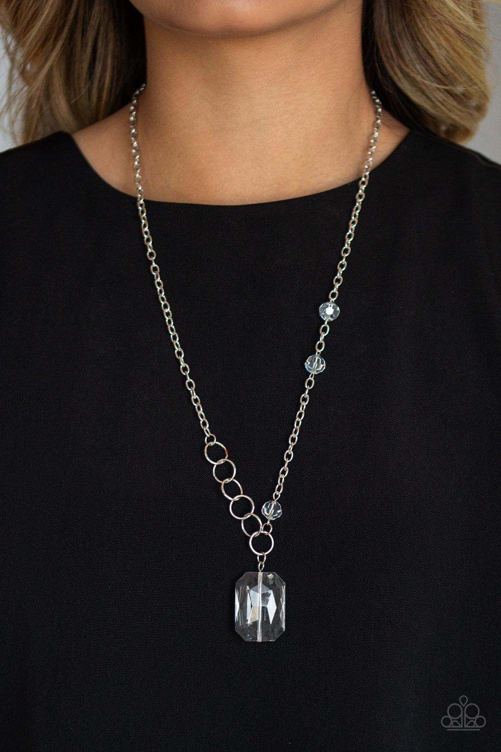 Paparazzi Accessories Never a Dull Moment - White A trio of glassy white crystal-like beads asymmetrically trickle along a mismatched silver chain. Featuring a regal emerald-cut, an oversized white gem swings from the bottom of the silver chain for a glam