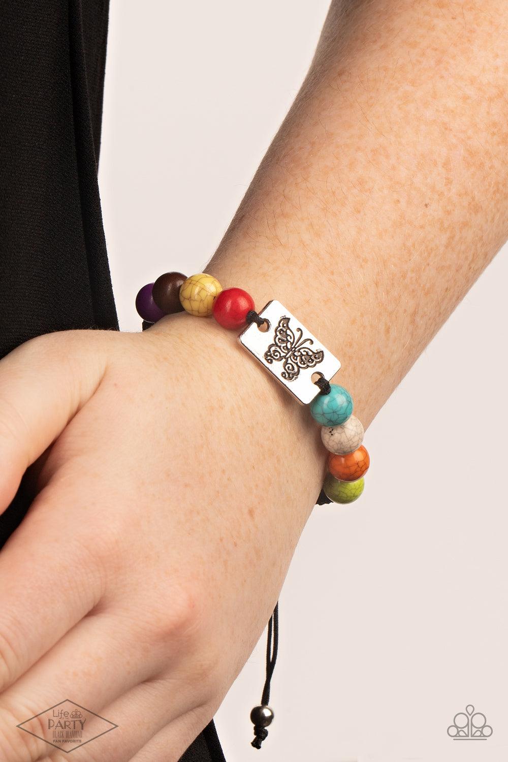 Paparazzi Accessories The Butterfly Effect A butterfly engraved on a metal rectangle plate sits in the center of a string of multicolored marble-like stones finished in a smooth cracked surface. The earthy colored stones combined with the worn metal butte