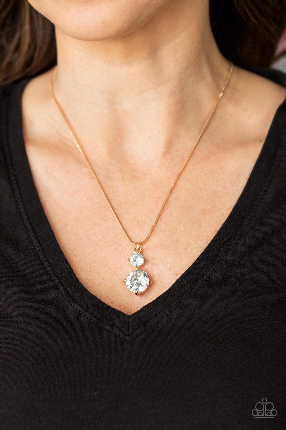Paparazzi Accessories Top Dollar Diva - Gold Nestled inside classic gold prongs, two oversized white rhinestones slide along a dainty gold snake chain, creating a dramatic pendant below the collar. Features an adjustable clasp closure. Sold as one individ