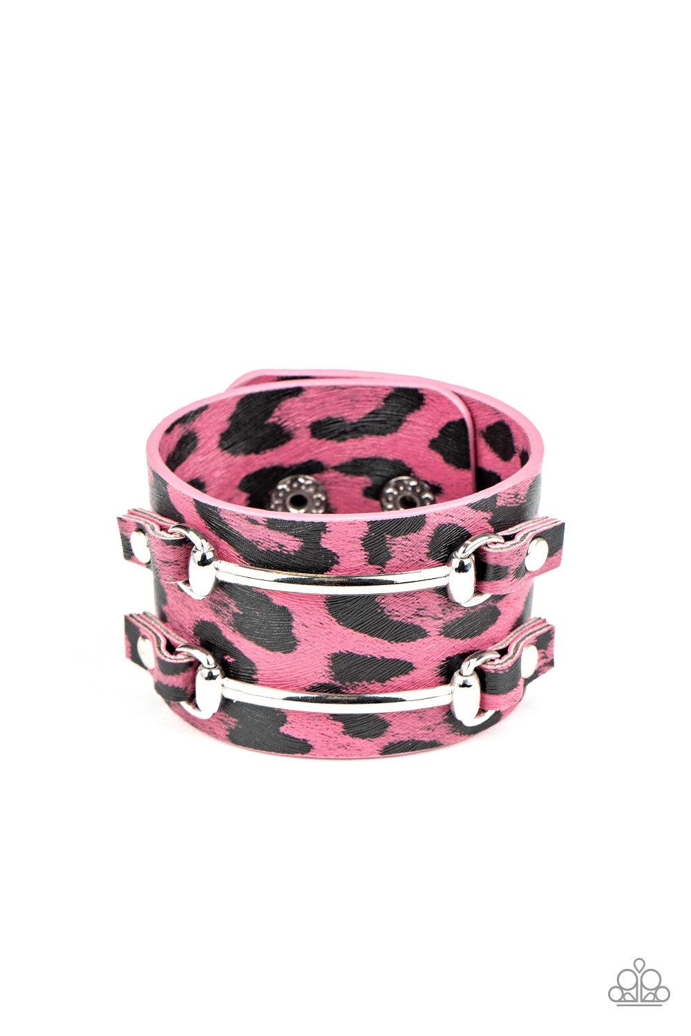 Paparazzi Accessories Safari Scene - Pink Two arcing silver bars are studded in place across the front of a thick leather band painted in pink and black cheetah print for a wild look. Features an adjustable snap closure. Sold as one individual bracelet. J