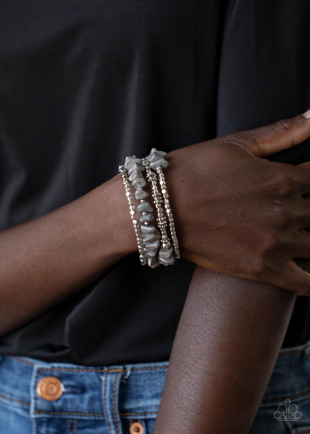 Paparazzi Accessories Rockin Renegade - Silver An earthy collision of Sleet stone beads, silver cubes, and decorative silver accents are threaded along a silver wire that coils around the wrist, creating a whimsical infinity wrap bracelet. Sold as one ind