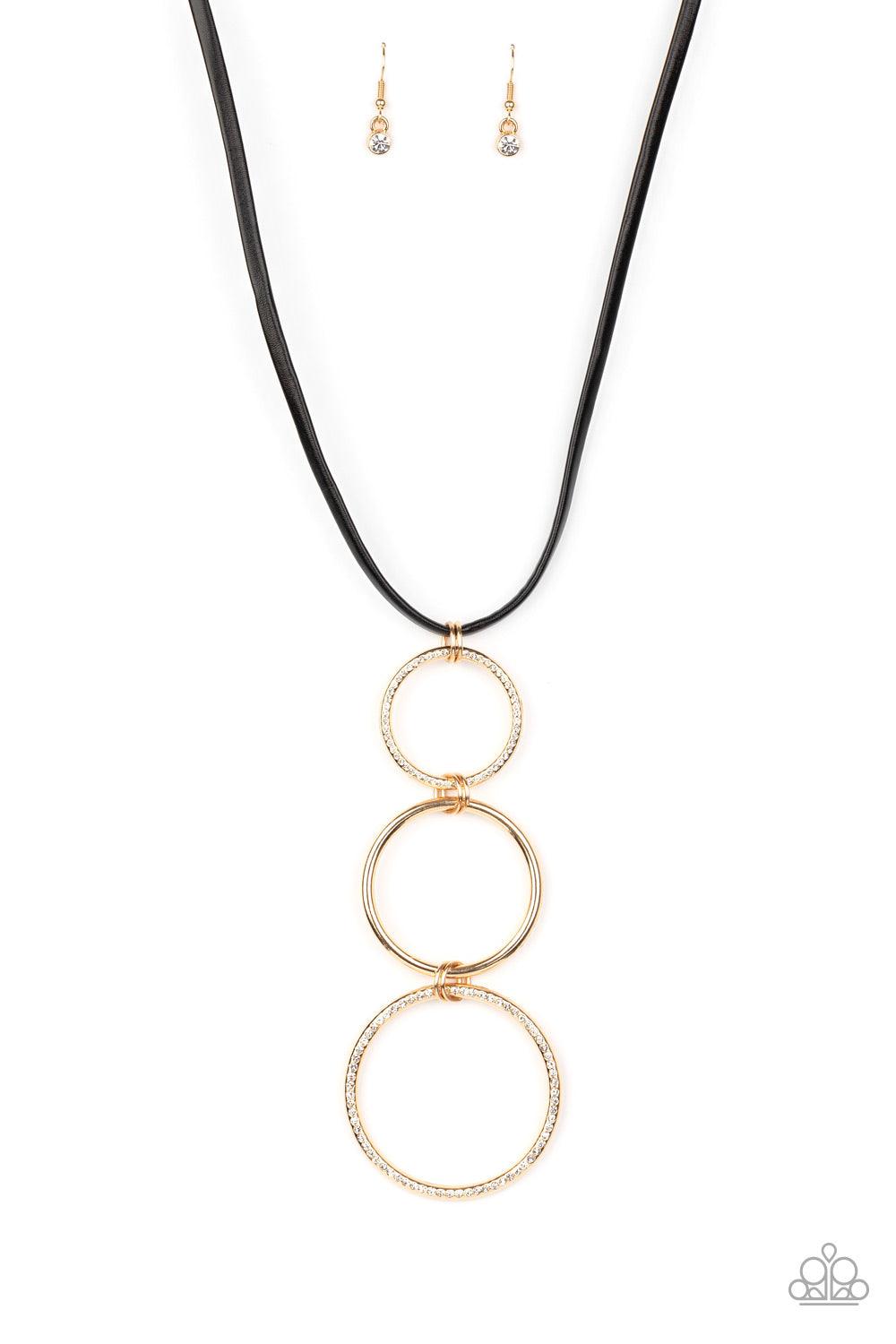 Paparazzi Accessories Curvy Couture - Gold Gradually increasing in size, two white rhinestone encrusted hoops link with a smooth gold hoop down the chest. The airy stacked pendant slides along a black leather cord for an elegantly edgy finish. Features an