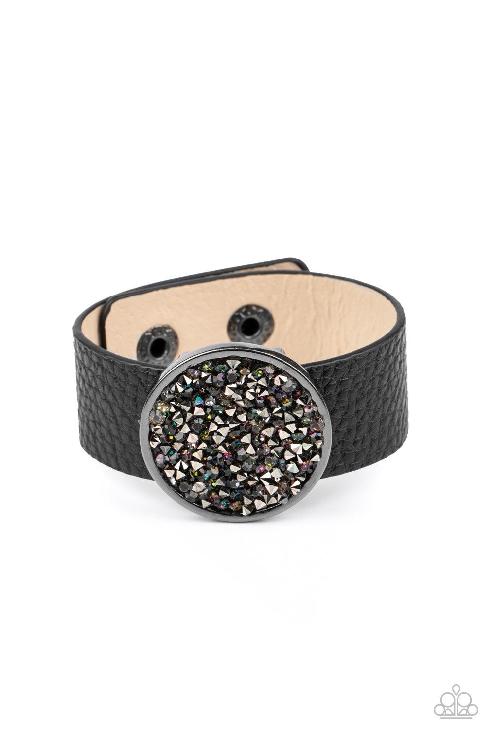 Paparazzi Accessories Stellar Escape - Multi A smoldering display of hematite and oil spill rhinestones scatter across the front of a gunmetal disc that glides along a black leather band for a stellar look. Features an adjustable snap closure. Sold as one
