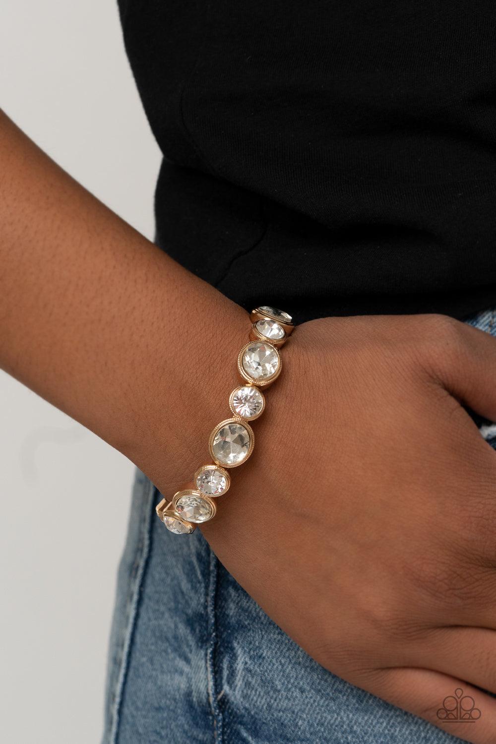 Paparazzi Accessories Still GLOWING Strong - Gold Encased in sleek gold frames, oval and round white rhinestones alternate along a stretchy band around the wrist for a timeless look. Sold as one individual bracelet. Jewelry